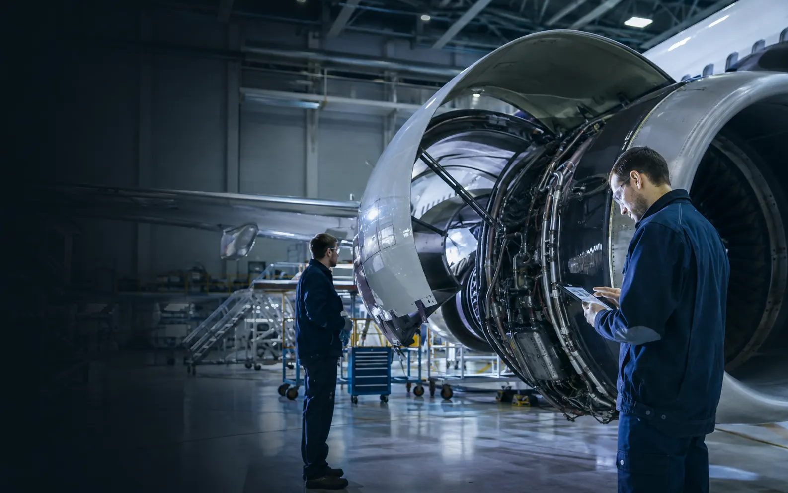 Aircraft maintenance engineers inspecting a turbofan engine